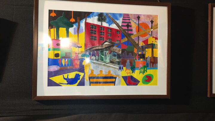 A framed, colorful abstract painting from Shantiniketan's renowned Fine Arts College, Kala Bhavana, hangs on a black background. The artwork depicts a mix of geometric shapes, silhouettes of people, and various objects like buildings, trees, and animals in a vibrant, overlapping collage.